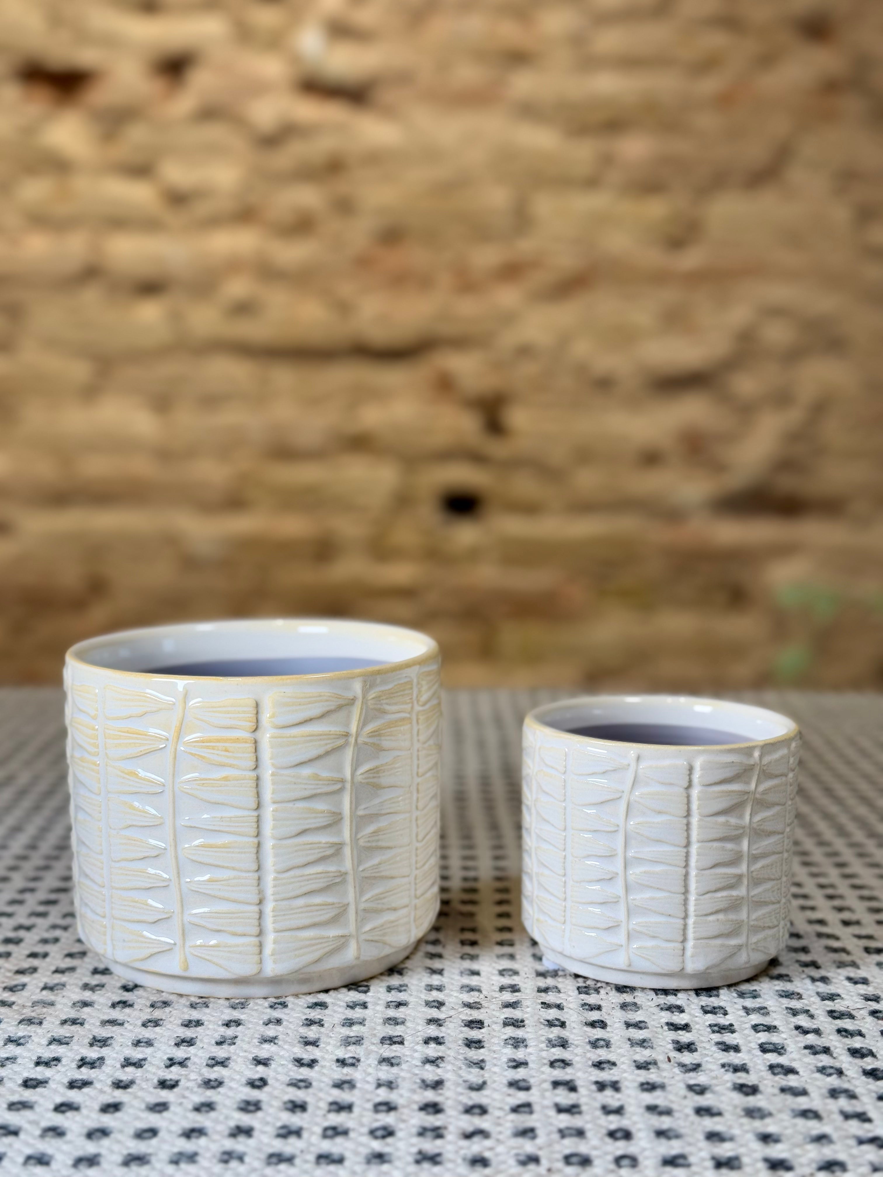 Macetas de cerámica blanca con relieve geométrico
