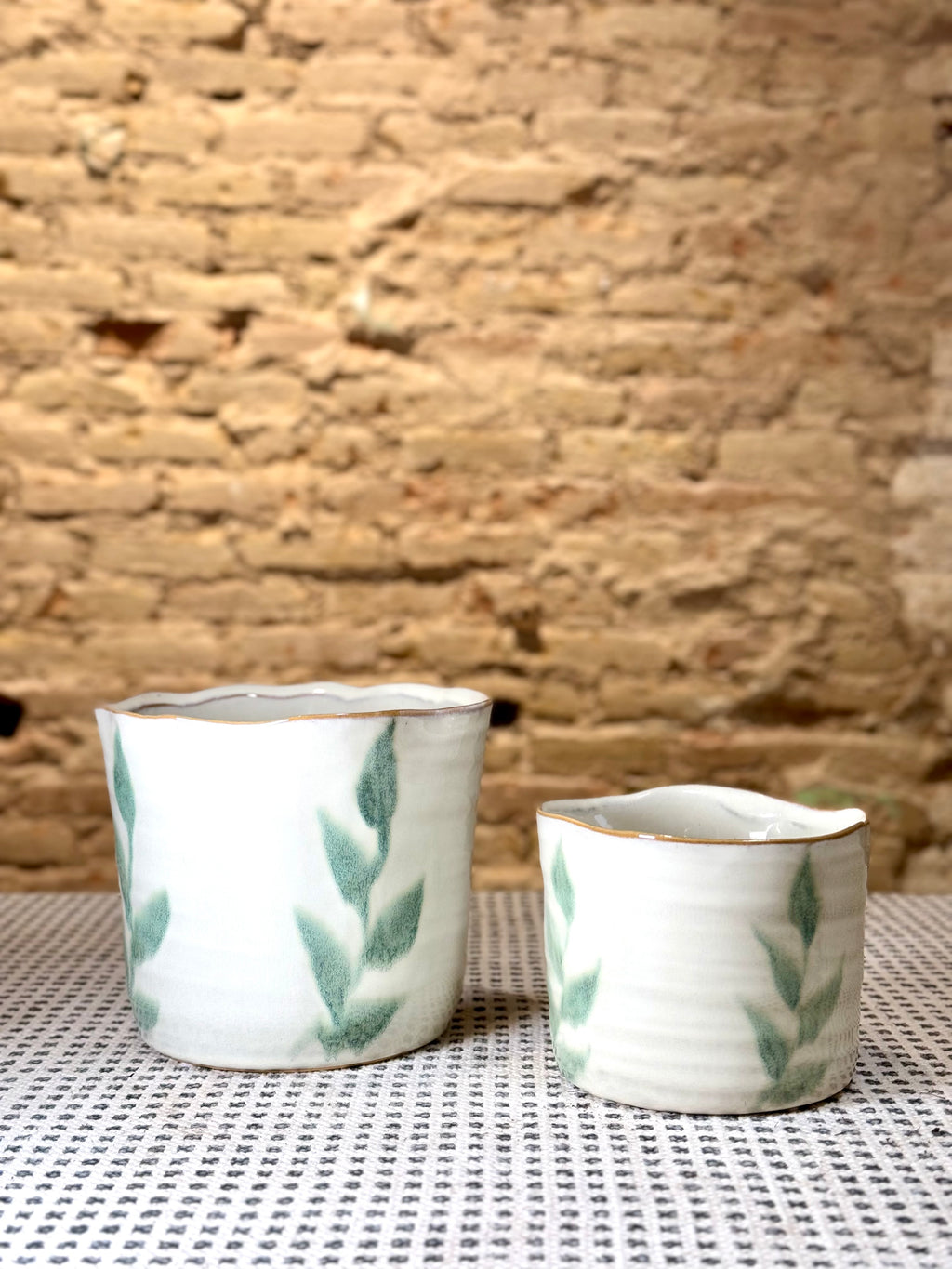 Macetas artesanales de cerámica blanca con diseño de hojas verdes