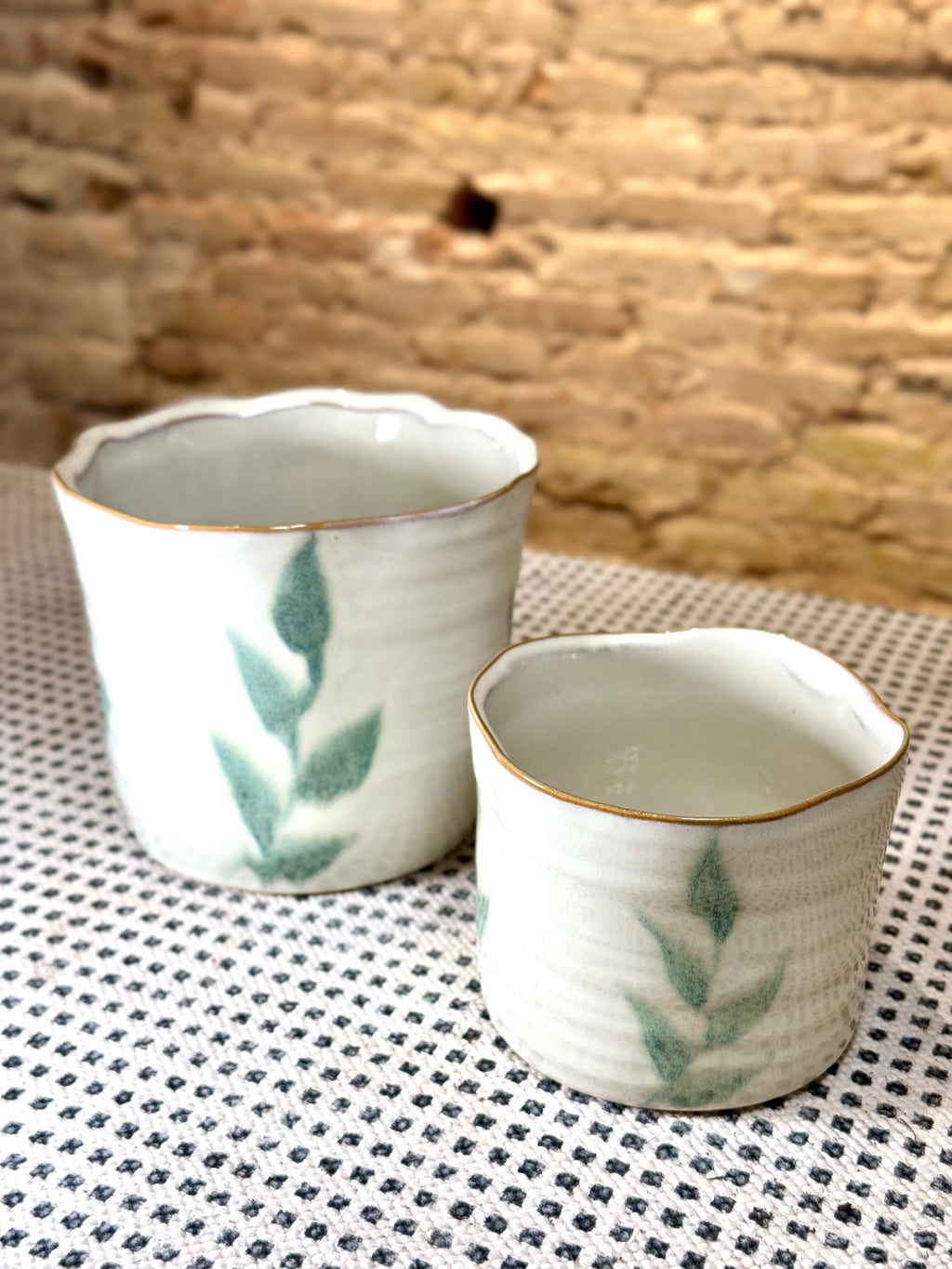 Macetas artesanales de cerámica blanca con diseño de hojas verdes