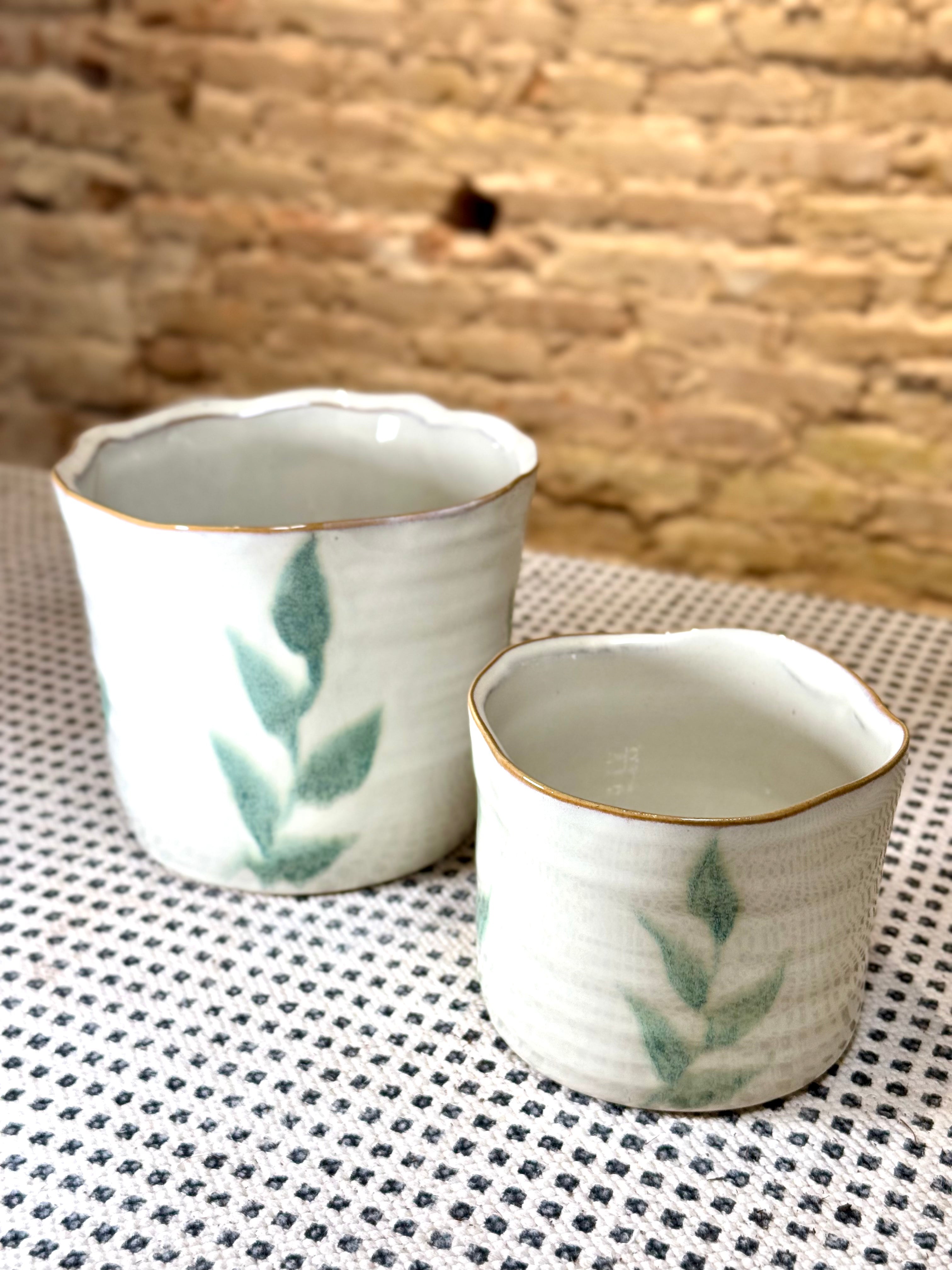 Macetas artesanales de cerámica blanca con diseño de hojas verdes