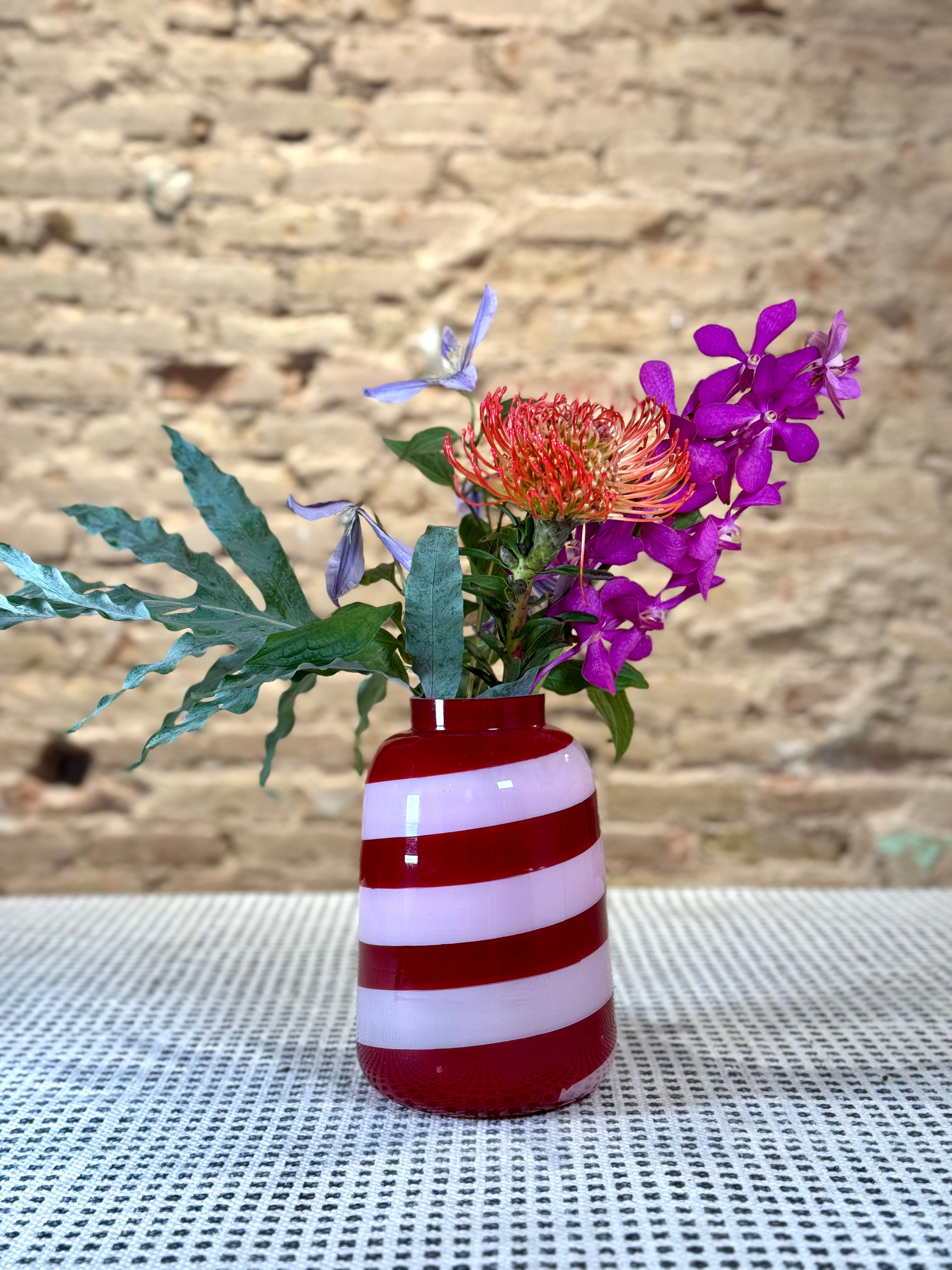 Florero de vidrio en colores vibrantes rosa y rojo con toque psicodélico para ramos grandes