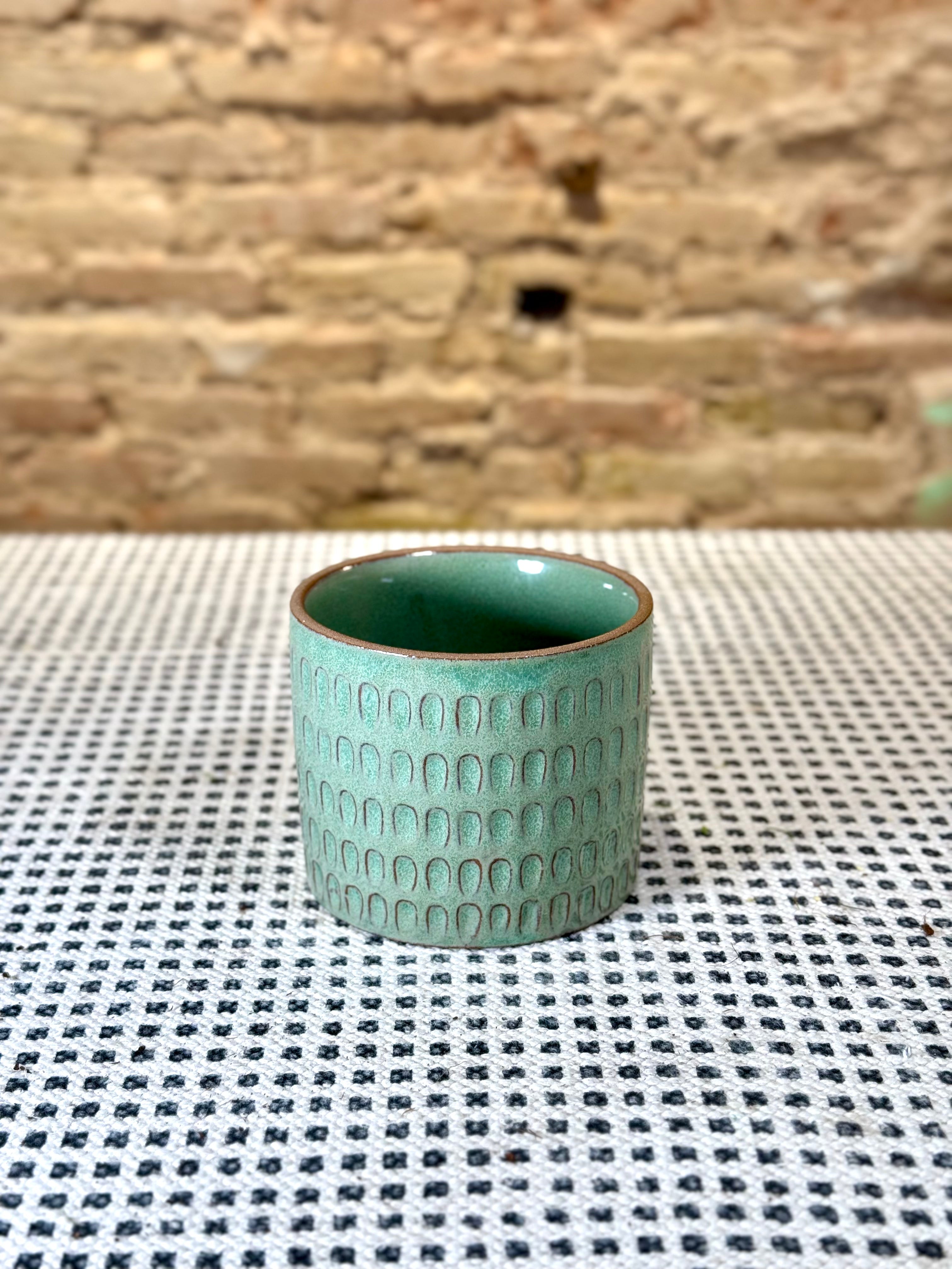 Portamacetas verde con motivos de escama