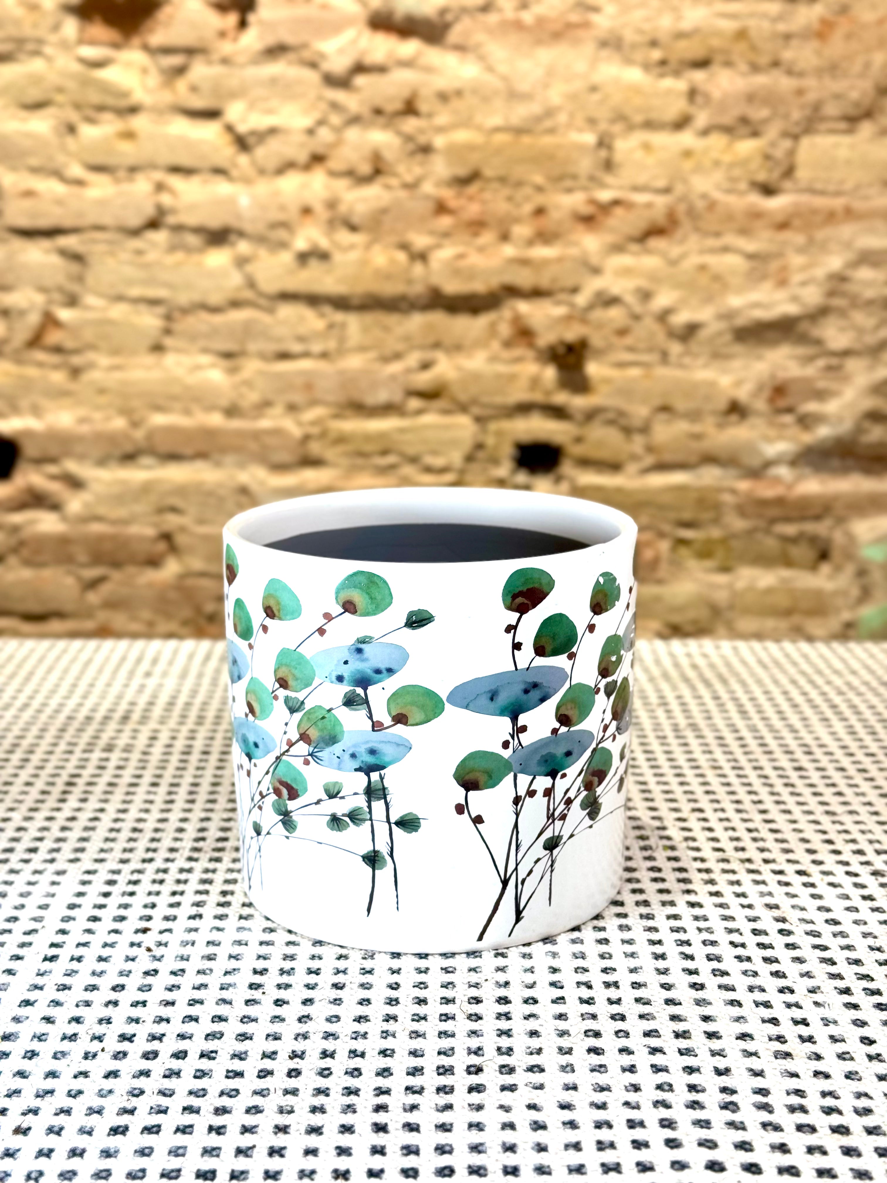 Portamacetas blanco con ramas y hojas verdes estilo japonés